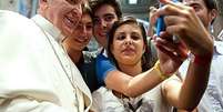 <p>Jovens tiram selfie com Papa Francisco; para especialista, piolhos podem ser transmitidos quando os jovens tiram fotos juntos</p>  Foto: AFP