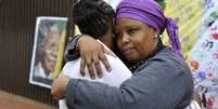 Duas mulheres se consolam em frente à casa em que Mandela morou em Soweto  Foto: Reuters