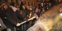 Ucraniano marreta estátua de Lênin, derrubada durante protestos contra o governo ucraniano em Kiev  Foto: AP