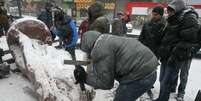 <p>Pessoas usam martelos para destruir a est&aacute;tua de Vladimir L&ecirc;nin em Kiev</p>  Foto: Reuters