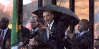 Obama discursa durante o funeral de Mandela; ao seu lado, o intérprete para a linguagem dos sinais  Foto: AFP