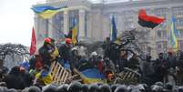 Manifestantes comemoram enquanto a polícia anti-distúrbios deixa a Praça da Independência, no centro de Kiev  Foto: AP