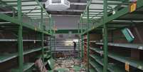 Comerciante inspeciona na terça-feira loja atacada em San Miguel de Tucumán   Foto: AP
