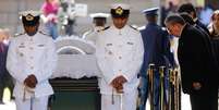 Raúl Castro presta homenagem a Nelson Mandela, ao lado do caixão do ex-presidente sul-africano  Foto: AFP