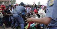 Polícia tenta conter a multidão que se empurra para chegar ao local onde o corpo de Mandela é velado  Foto: AP