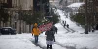 Pessoas caminham em via coberta pela neve no centro de Jerusal&eacute;m  Foto: AP