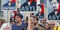 <p>Manifestantes seguram cartazes durante protesto em apoio a Edward Snowden, em Berlim</p>  Foto: Tobias Schwarz / Reuters