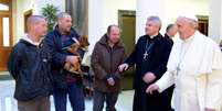 Francisco e o arcebispo Konrad Krajewski dão boas-vindas aos moradores de rua no Vaticano  Foto: L'Osservatore Romano / AP