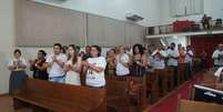 Familiares de vítimas da Boates Kiss batem palmas durante culto ecumênico em homenagem aos mortos na tragédia  Foto: Luiz Roese / Especial para Terra
