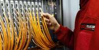 T&eacute;cnico da Telecom Italia trabalha com fibra &oacute;tica em central telef&ocirc;nica, em Roma, 20 de dezembro de 2013. As a&ccedil;&otilde;es da Telecom Italia se aproximaram de uma m&aacute;xima de dois meses nesta sexta-feira, impulsionadas por reportagem de que a espanhola Telef&oacute;nica estaria trabalhando em uma oferta conjunta pela TIM Participa&ccedil;&otilde;es, controlada pelo grupo italiano e que seria desmembrada.  Foto: Alessandro / Reuters