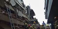 Equipes procuram por operários soterrados após o desabamento de um prédio em Goa  Foto: AP