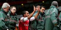 Theo Walcott provoca torcedores do Tottenham enquanto sai de maca; jogador do Arsenal lesionou o joelho e ficará seis meses longe dos gramados  Foto: Getty Images 