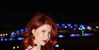 <p>Anna sustenta uma pose femme fatale com os cabelos pintados de vermelho</p>  Foto: Getty Images 