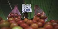 <p>Vendedos ergue sacolas de tomates em feira livre no bairro da Mooca, em São Paulo</p>  Foto: Nacho Doce / Reuters