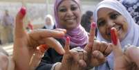 Mulheres egípcias exibem os dedos pintados depois de votar, no Cairo  Foto: AP