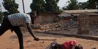 Foto de 31 de dezembro mostra membro de legião de um bairro de Bangui agredir corpo de homem muçulmano  Foto: AP