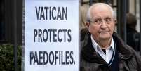 Homem exibe cartaz em protesto contra os casos de pedofilia no Vaticano em frente a sede da ONU em Genebra  Foto: AFP