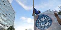 <p>Estudantes da Univerisade Gama Filho hasteiam bandeira da institui&ccedil;&atilde;o em frente ao Minist&eacute;rio da Educa&ccedil;&atilde;o (MEC), em Bras&iacute;lia</p>  Foto: Valter Campanato / Agência Brasil