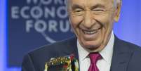 Shimon Peres sorri com o "Espírito de Davos" em mãos  Foto: AP