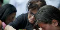 <p>Familiares de uma das vítimas da tragédia em Santa Maria choram sobre o caixão</p>  Foto: Mauro Pimentel / Terra