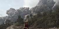 <p>Aldeão corre após o vulcão Monte Sinabung entrar em erupção neste sábado, na ilha ocidental de Sumatra</p>  Foto: S Aditya / Reuters