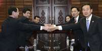 Representantes das Coreias se cumprimentam durante reunião  Foto: AP