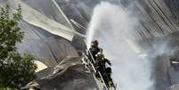 Sete pessoas morreram por causa do desabamento de parte da alvenaria do edifício, enquanto as equipes de emergência iniciavam as tarefas para apagar o incêndio  Foto: EFE