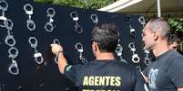 Policiais federais penduram algemas em protesto por aumento salarial  Foto: Antonio Cruz / Agência Brasil