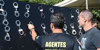 Policiais federais penduram algemas em protesto por aumento salarial  Foto: Antonio Cruz / Ag&ecirc;ncia Brasil