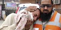 Membro da equipe de emerg&ecirc;ncia consola parente de uma das v&iacute;timas fatais do atentado em Peshawar, Paquist&atilde;o, nesta segunda-feira  Foto: EFE