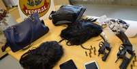Armas e disfarces usados pelo trio no esquema montado para assaltar agências dos Correios  Foto: Polícia Federal / Divulgação