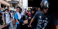 Estudante ferido é socorrido por manifestantes em Caracas  Foto: AP