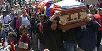 Parentes carregam o caixão de Juan Montoya, conhecido como "Juancho", que foi um dos três mortos durante o recente protesto em Caracas  Foto: AFP