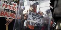 Manifestantes seguram placas e cartazes durante protesto contra o governo, em Caracas  Foto: Reuters