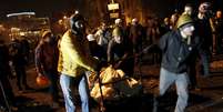 Manifestantes antigoverno empurram carrinho com sacolas cheias de pedras para construer barricadas no centro de Kiev  Foto: Reuters