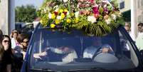 Familiares de Génesis Carmona se abraçam dentro do carro fúnebre que leva o corpo da modelo, durante seu funeral na sexta-feira, 21 de fevereiro  Foto: AP