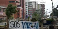 Mulher venezuelana sentada em rua bloqueada em San Cristobal, capital do estado de Tachira, em 23 fevereiro  Foto: AFP