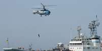 Helicóptero russo sobrevoa navio de guerra ucraniano durante exercício militar em Sebastopol, em maio de 2011  Foto: AFP