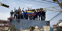 <p>Manifestantes sobem em um cont&ecirc;iner, usado como barricada em uma rua de San Crist&oacute;bal, capital do estado de Tachira, na Venezuela</p>  Foto: AFP