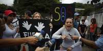 Manifestante grita perto da embaixana cubana em Caracas  Foto: Reuters