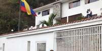 <p>Membros da Inteligência da Guarda Nacional da Venezuela em frente à casa do ex-general oposicionista Angel Vivas, enquanto ele espera armado, em 23 de fevereiro</p>  Foto: AFP