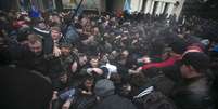 Ucranianos empurram uns aos outros durante confrontos em frente ao parlamento da Crimeia  Foto: Reuters