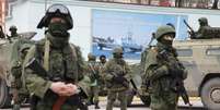 Soldados armados ao lado de veículos do exército russo esperam do lado de fora de um posto de guarda de fronteira na cidade de Balaclava, na Crimeia, em 1 de março  Foto: Reuters