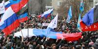 Manifestantes pró-Rússia seguram bandeiras do país durante protesto no centro de Donetsk, na Ucrânia, neste sábado, 1 de março  Foto: AP