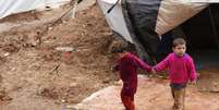 Crianças sírias refugiadas andam pela lama no campo de refugiados Bab Al-Salam, em Azaz. O governo da Síria prometeu maior acesso para os grupos de ajuda que prestam assistência a milhões de sírios, mas é preciso progredir mais rápido para lidar com a grave crise humanitária, disse o chefe do Unicef nesta sexta-feira. 14/03/2014  Foto: Hamid Khatib / Reuters