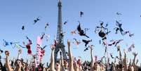 <p>Com a torre Eiffel ao fundo, mulheres chamam a atenção sobre o cancer de mama</p>  Foto: AFP