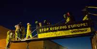 <p>Ativistas do Greenpeace penduram um banner dizendo "Parem de colocar a Europa em risco", ao lado de um dos reatores da central nuclear de Fessenheim, no leste da França, nesta terça-feira, 18 de março</p>  Foto: AP