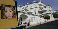 Pessoas passam perto de um painel com a foto de Madeleine no resort turístico da Praia da Luz, em Portugal.  Foto: Hugo Correia / Reuters