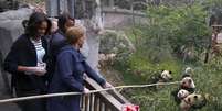<p>Michelle e as filhas deram pedaços de maçãs fixados na ponta de uma longa vara de bambu aos pandas</p>  Foto: AP