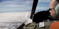 <p>Oficial olha para fora do cockpit de um avi&atilde;o da For&ccedil;a A&eacute;rea australiana, enquanto busca pelo voo MH370 da Malaysian Airlines&nbsp;sobre o Oceano &Iacute;ndico meridional,&nbsp;em 27 de mar&ccedil;o</p>  Foto: AFP